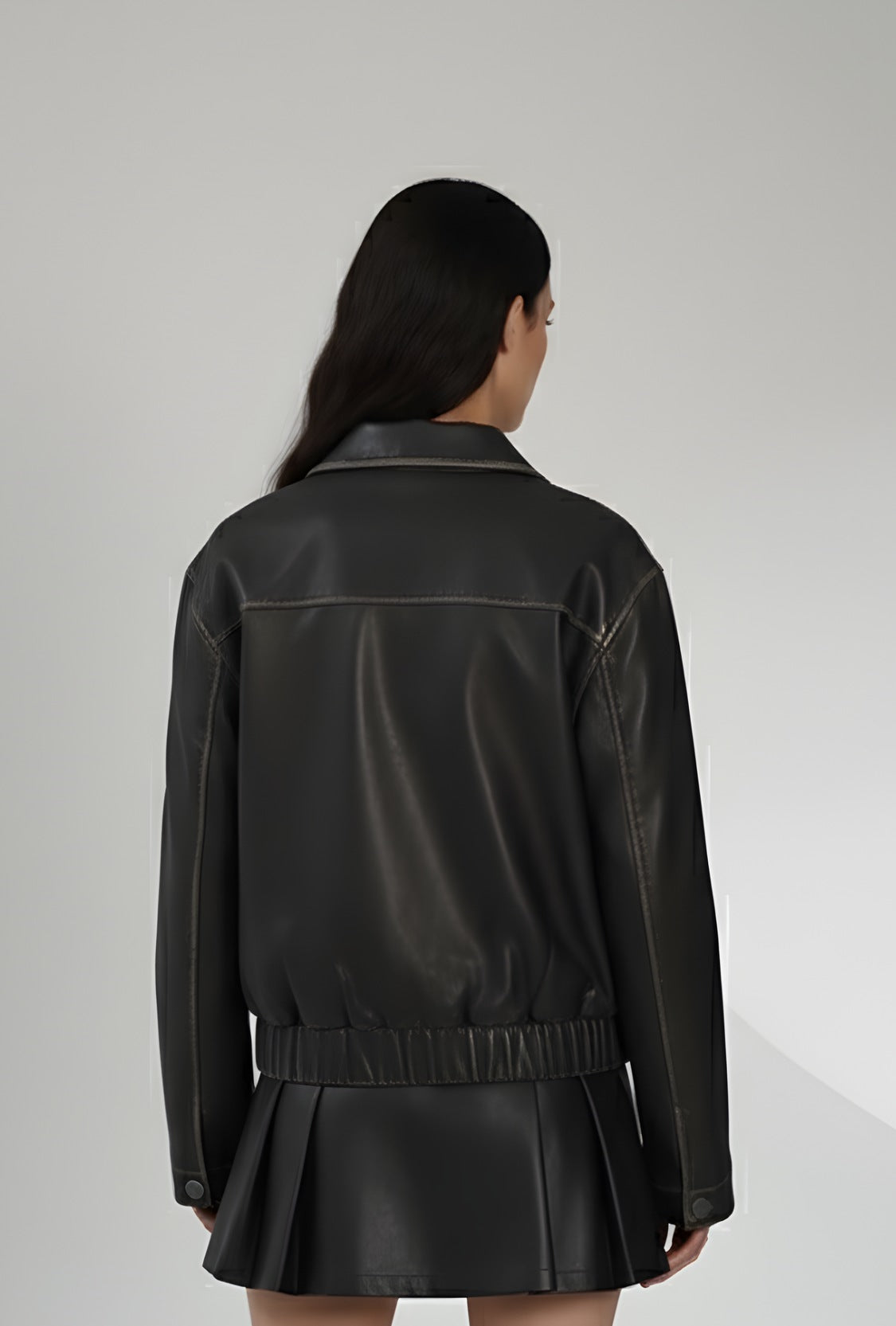 Czarna skórzana kurtka z zamkiem i dekoracyjnymi kokardkami na piersi