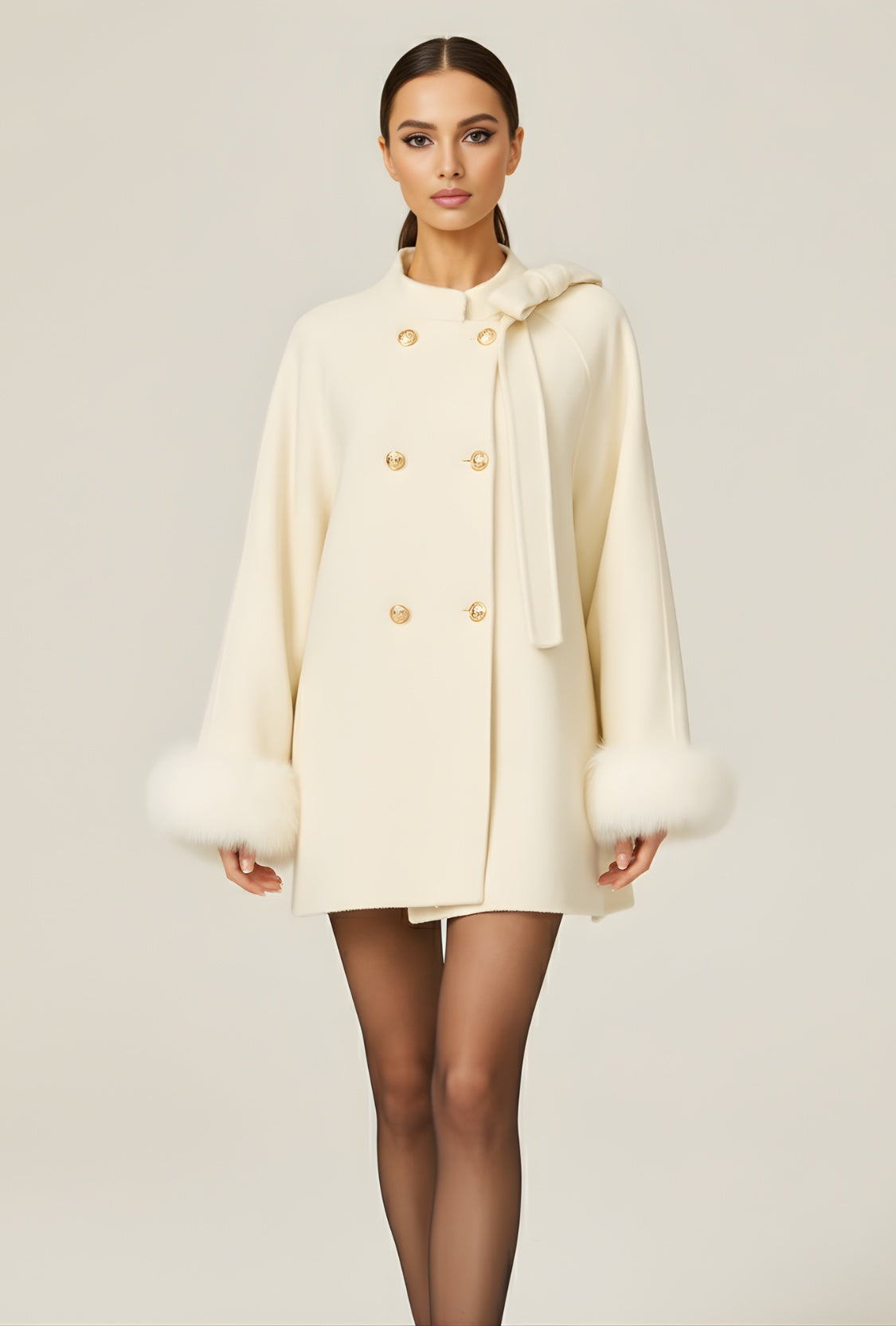 Biały krótki płaszcz z kokardą i futrzanymi mankietami z tkaniny wełnianej