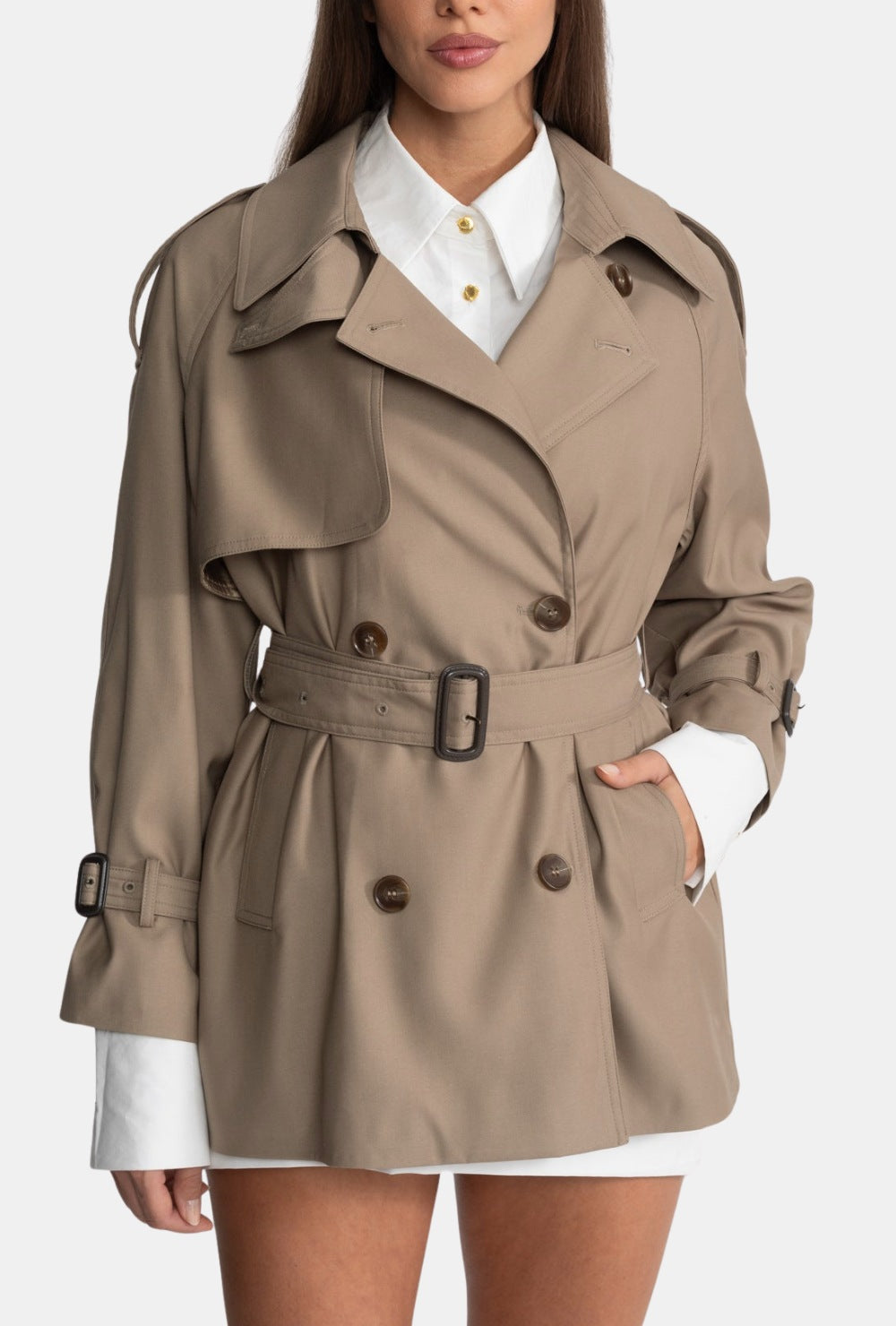 Beżowy krótki trencz z paskiem i podwójnym zapięciem na guziki