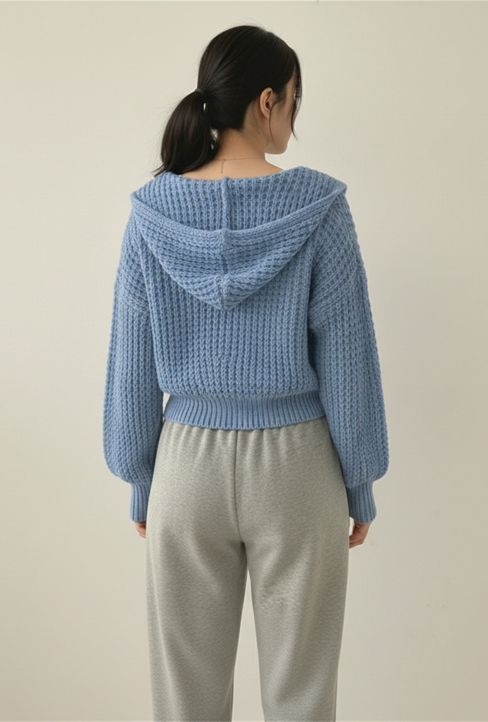 Krótki kardigan z kapturem z grubej dzianiny o wyraźnym splocie na suwak