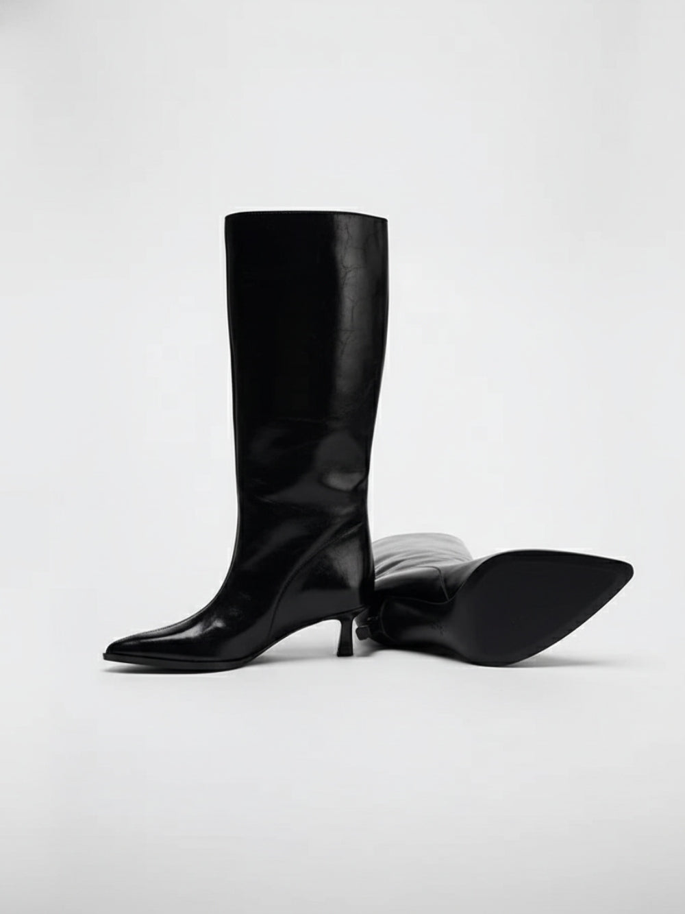 Czarne kozaki przed kolano z lekko połyskującej sztucznej skóry ze szpiczastym noskiem na niskiej szpilce