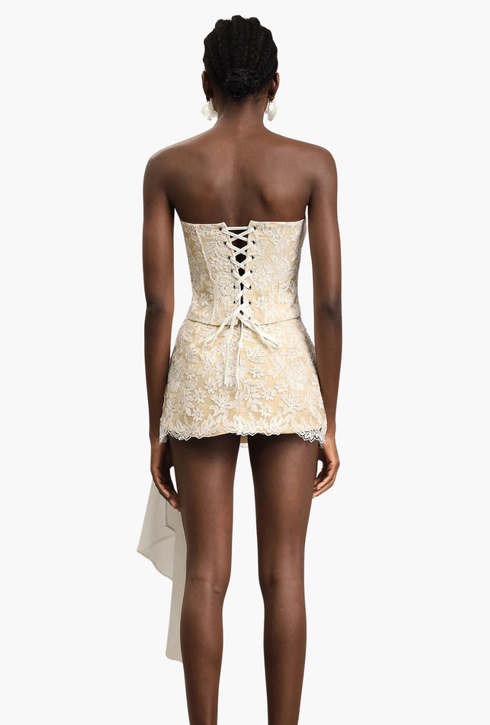 Koronkowy komplet kremowo-beżowy z gorsetem bez ramiączek, kokardką i mini spódniczką z marszczeniem oraz trenem