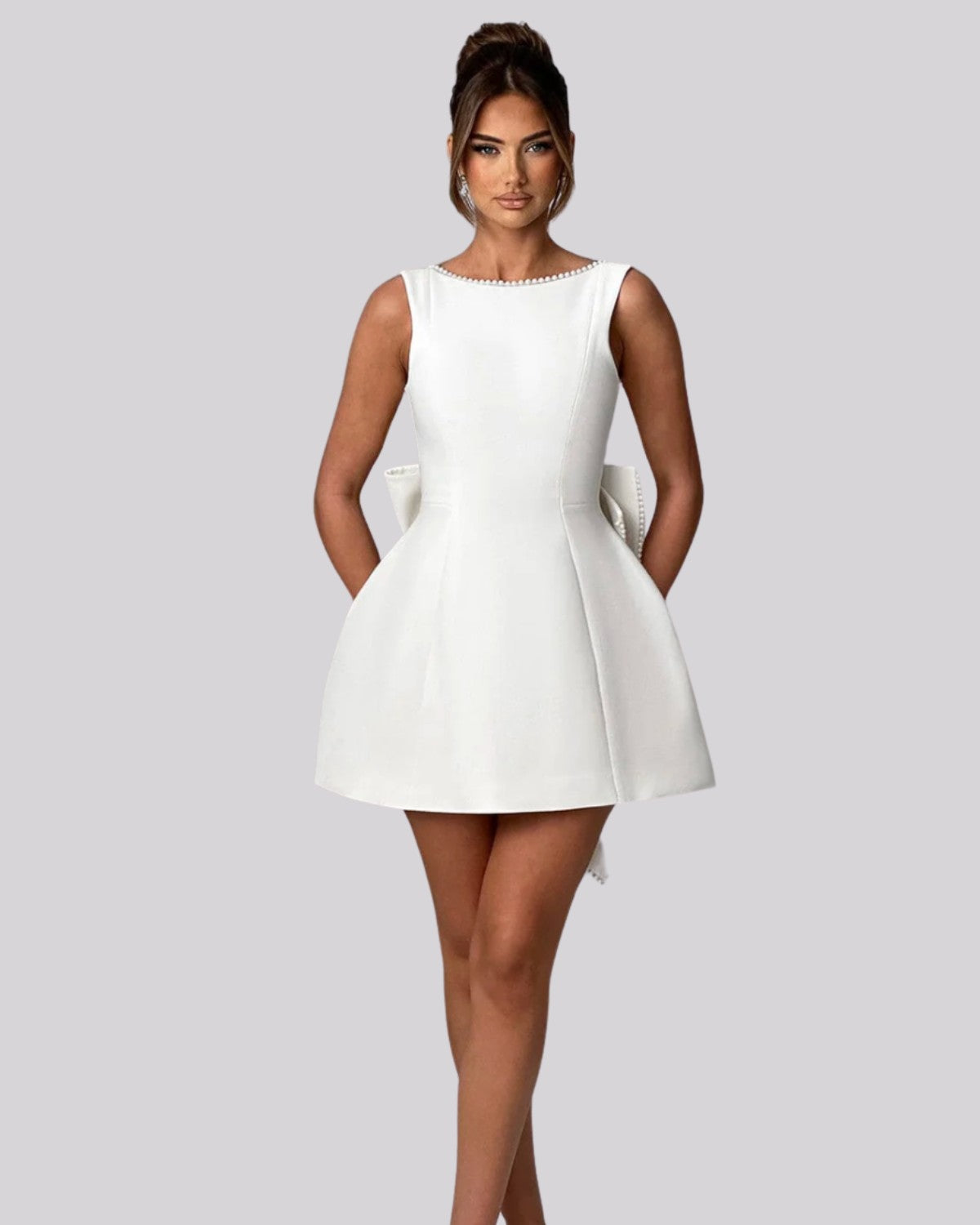 Elegancka sukienka mini z dużą kokardą z tyłu i perełkami