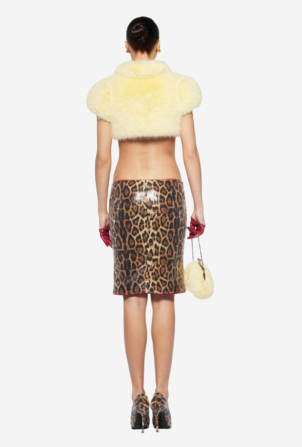 Żółte krótkie futrzane bolerko z wysoką stójką i trzema czarnymi paskami z klamrami z przodu