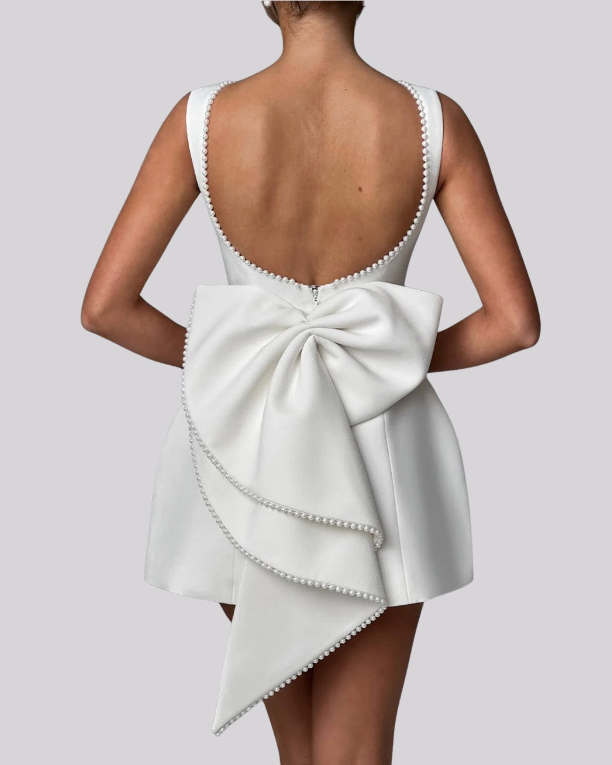 Elegancka sukienka mini z dużą kokardą z tyłu i perełkami