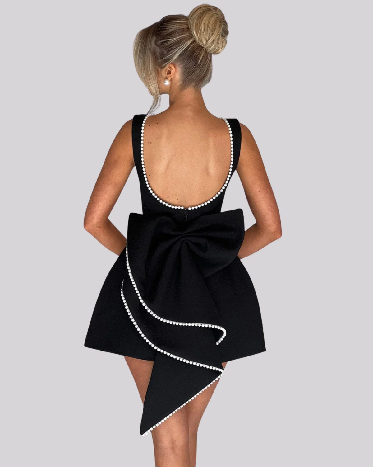 Elegancka sukienka mini z dużą kokardą z tyłu i perełkami