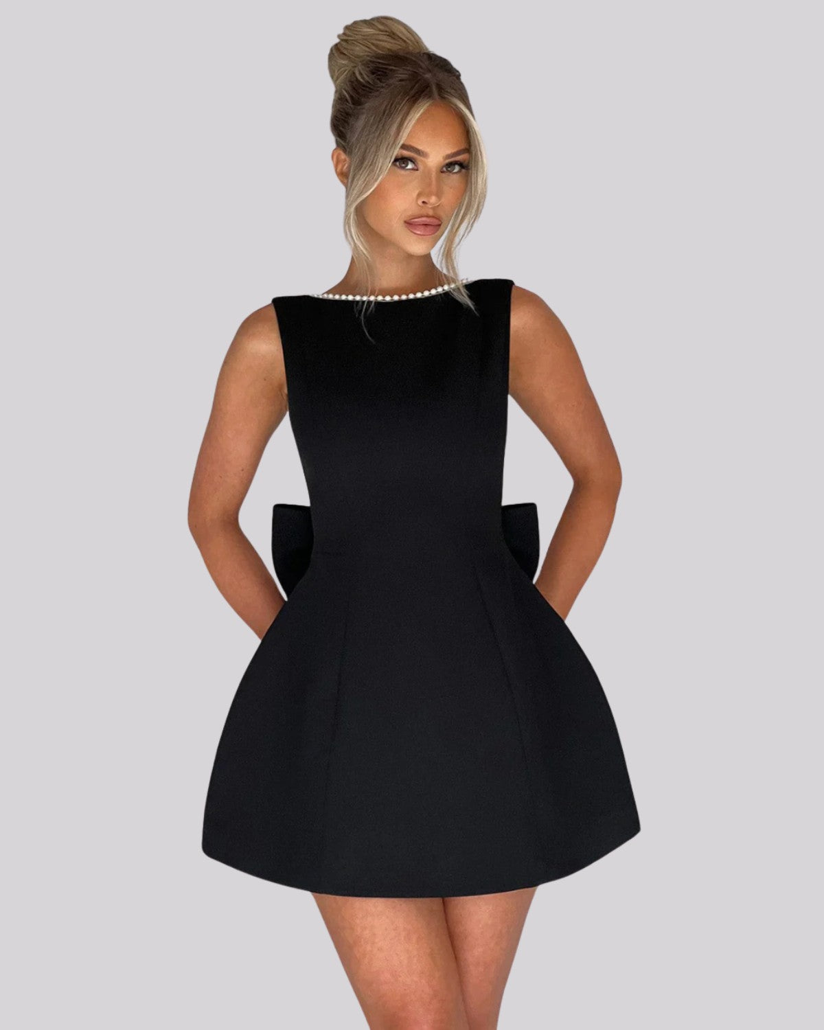 Elegancka sukienka mini z dużą kokardą z tyłu i perełkami