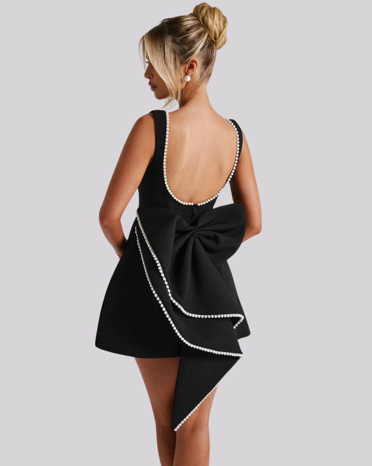 Elegancka sukienka mini z dużą kokardą z tyłu i perełkami