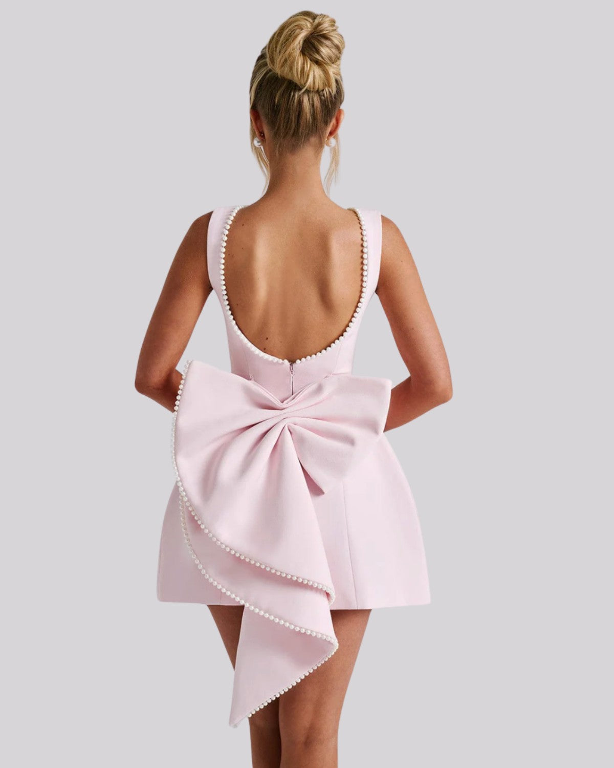 Elegancka sukienka mini z dużą kokardą z tyłu i perełkami